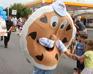 Chocolate Chip Charlie shakes hands with the children along the parade route at the Kensington Labor Day Parade